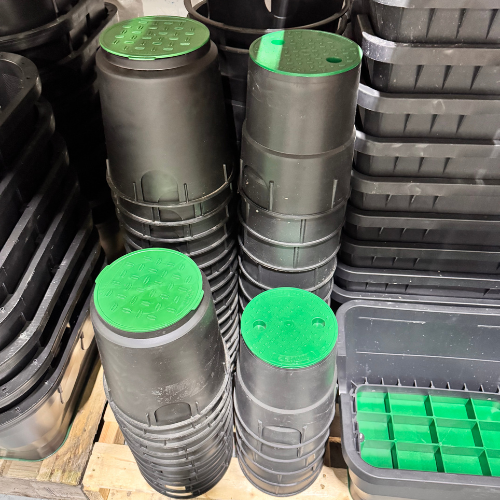 A heavy-duty green rectangular irrigation valve box installed level with the grass in a residential lawn.