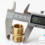 Using a digital caliper to measure the outer peak diameter of a black plastic male threaded BSP nipple fitting according to the standard sizing chart.
